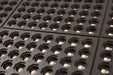Close up product image of black anti-fatigue 24/seven Interlocking mat with holes available in natural or nitrile rubber.