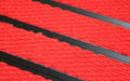 Close up image of Bright Red Superguard inserts in Black ARCHIMAT aluminium architectural matting