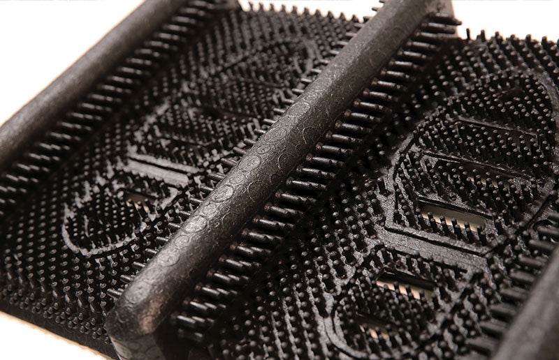 Angle product image of black rubber Mud Chucker that scrapes mud off shoes