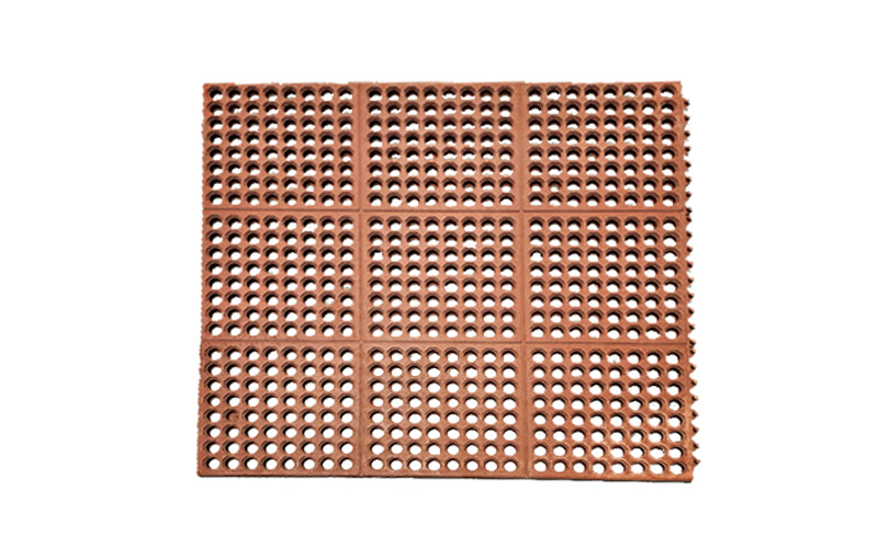 Full product image of the red 24/seven interlocking mat with holes made from natural rubber,