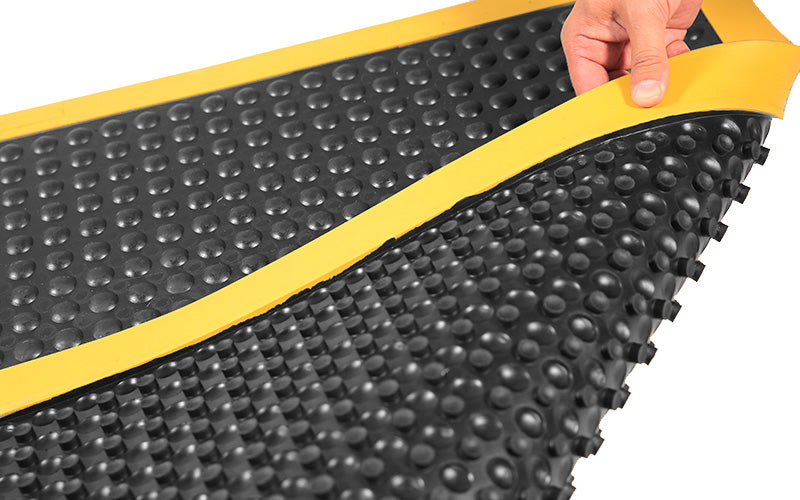 Peel back image of the front and back of the black and yellow supreme comfort mat with suction cups on the back for extra grip. The Mat Group AUS.