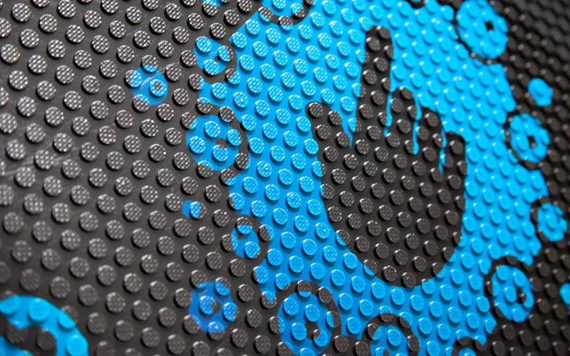 Close up image of a blue custom logo, digitally printed on a rubber scraper logo mat.