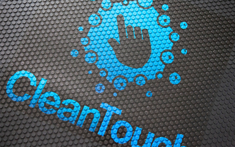 Close up image of a blue custom logo, digitally printed on a rubber scraper logo mat.