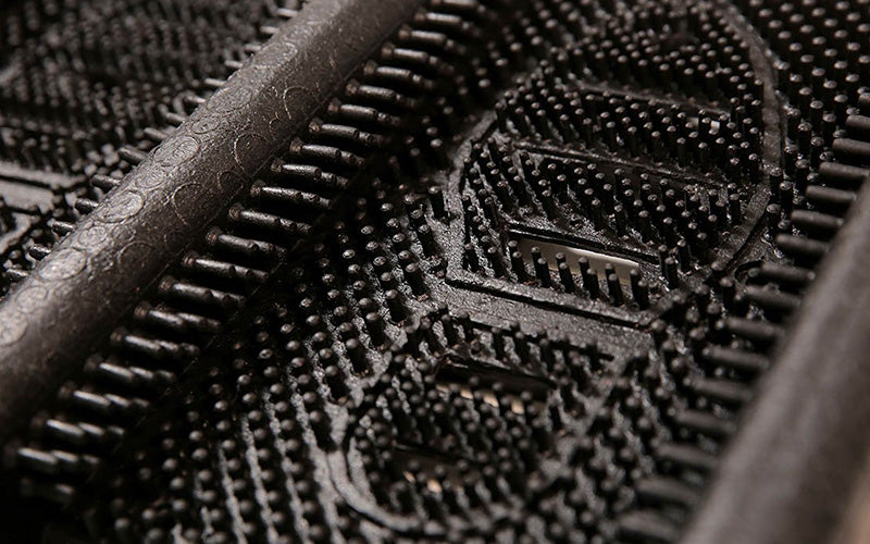 Close up product image of black rubber Mud Chucker that scrapes mud off shoes