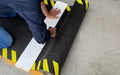 Insitu product image of non-slip, black and yellow Smartgrip Industrial matting Roll being cut with cutting board and safety knife