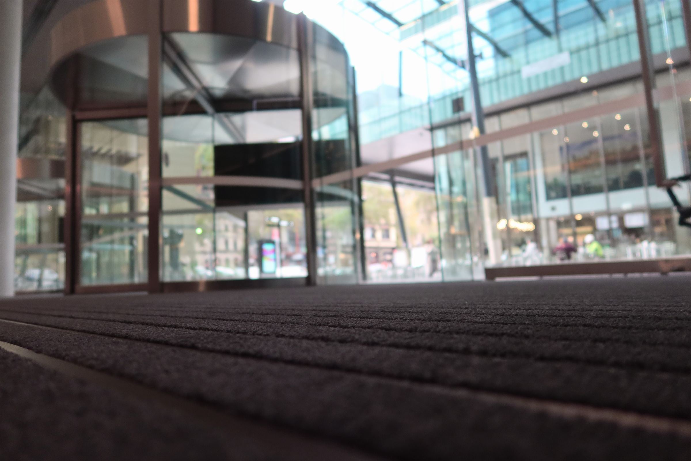 ARCHIMAT aluminium entrance matting installed at a commercial entrance with revolving doors