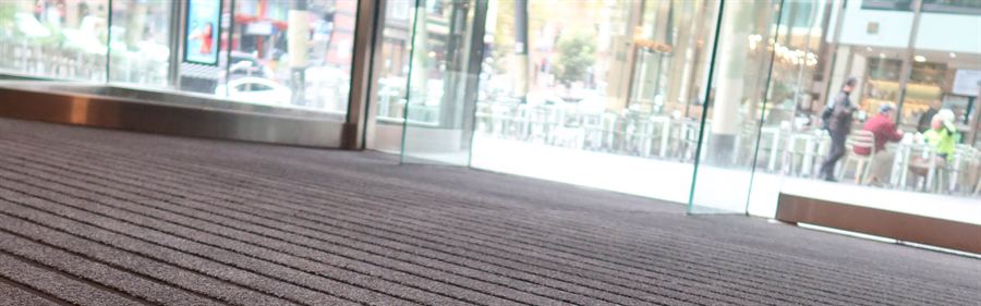 Ribbed entrance matting running across the doorway of a retail shopfront